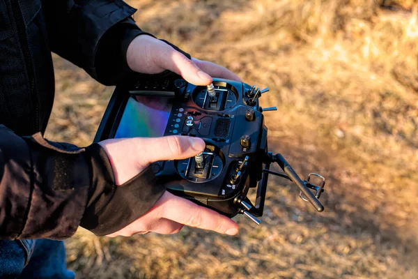 Quadcopter uzaktan kontrole sahip eller, toprak arkaplan