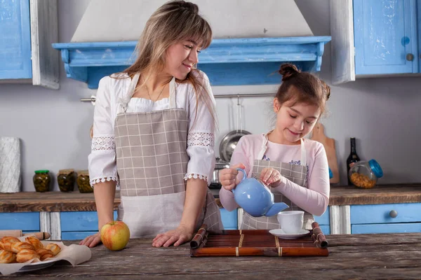 Güzel bir kadın ve küçük sevimli bir kız mutfakta birlikte yemek pişirir, çay hazırlar ve eğlenir, anne ve ev kadınlarının ideal eş kavramının vücut bulmuş hali.