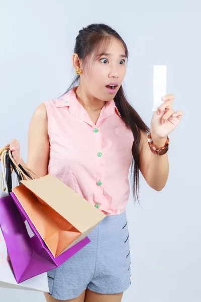 Mujer joven impactante después de comprobar el recibo en su mano — Foto de Stock