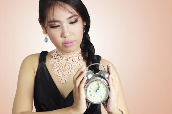 Mujer asiática sosteniendo un reloj . — Foto de Stock