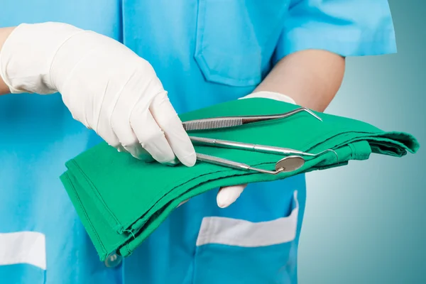 Primo piano del dentista mano prendendo specchio da su di strumenti dentali . — Foto Stock