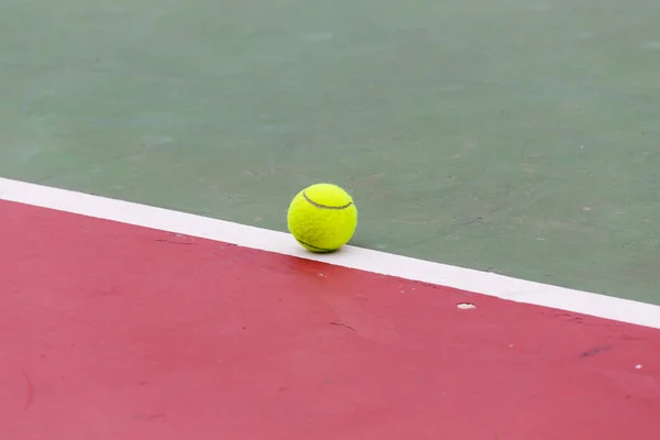 Tennisboll på domstolen på nära håll med netto i bakgrunden — Stockfoto