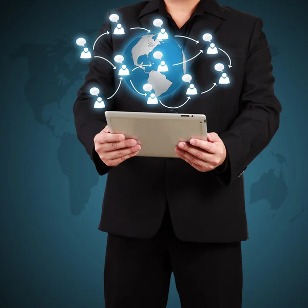 Businessman holding a tablet with globe and community icons. Con Stock Picture