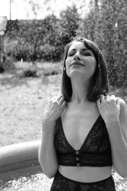 Yüzme havuzunda siyah beyaz iç çamaşırlı güzel bir kadın. 