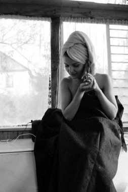 Kafasında havluyla balkonda poz veren güzel esmer kadın. 