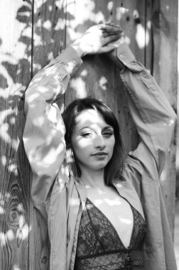 Gömlek ve iç çamaşırı giymiş güzel esmer kadın dışarıda poz veriyor. 