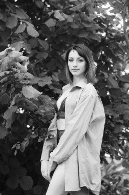 Gömlek ve iç çamaşırı giymiş güzel esmer kadın dışarıda poz veriyor. 