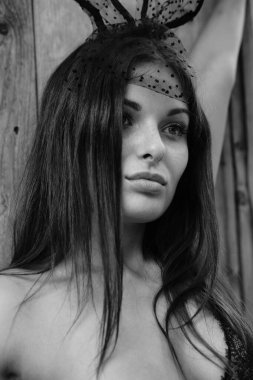 İç çamaşırı ve dekoratif tavşan kulakları takmış güzel, esmer bir kadın. 