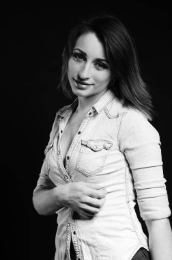 Stüdyoda siyah arka planda poz veren güzel genç bir kadın, moda tarzı, siyah beyaz fotoğraf.