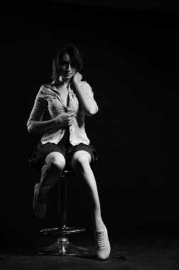 Stüdyoda siyah arka planda poz veren güzel genç bir kadın, moda tarzı, siyah beyaz fotoğraf.