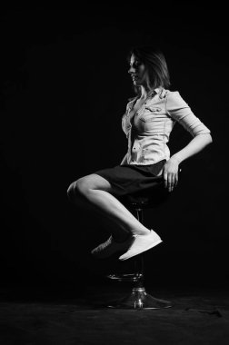 Stüdyoda siyah arka planda poz veren güzel genç bir kadın, moda tarzı, siyah beyaz fotoğraf.