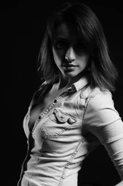 Stüdyoda siyah arka planda poz veren güzel genç bir kadın, moda tarzı, siyah beyaz fotoğraf.