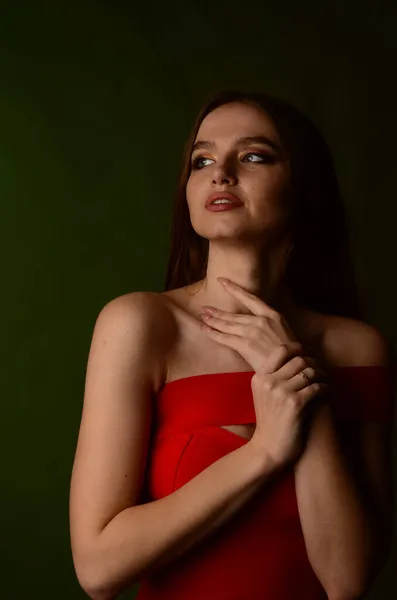 スタジオで赤いドレスを着た美しい若い女の子 高級ジュエリー ネックレス リング 明るいメイク 赤い唇 マニキュア グラマラス高級女性 — ストック写真