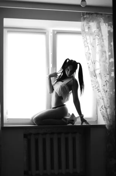 性感的年轻的黑发女人穿着内裤在窗上飘扬 黑白照片 — 图库照片