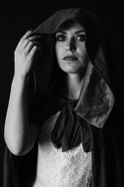 Siyah arka planda poz veren güzel bir kadın, siyah beyaz bir fotoğraf.