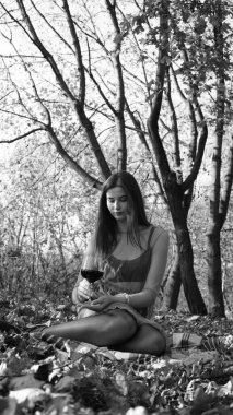 Bir sonbahar günü kameraya poz veren genç bir kadın. Siyah beyaz fotoğraf