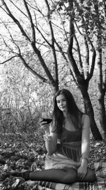 Bir sonbahar günü kameraya poz veren genç bir kadın. Siyah beyaz fotoğraf