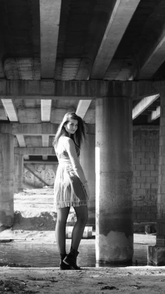秋天的一天 一个年轻的女人在桥下的摄像机前摆姿势 黑白照片 — 图库照片