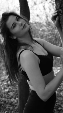 Bir sonbahar günü kameraya poz veren genç bir kadın. Siyah beyaz fotoğraf