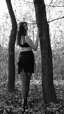 Bir sonbahar günü kameraya poz veren genç bir kadın. Siyah beyaz fotoğraf