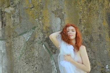 Denizde poz veren güzel çıplak genç bir kadın. Seksi, çıplak kızıl yaz tatilinin tadını çıkarıyor.