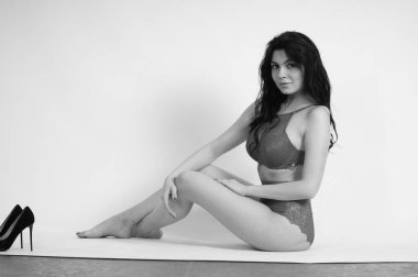 Stüdyoda iç çamaşırlı güzel bir kadın poz veriyor.