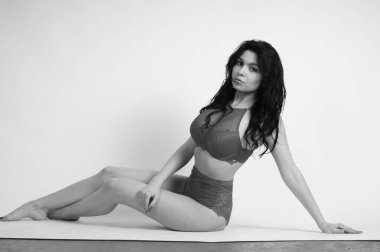 Stüdyoda iç çamaşırlı güzel bir kadın poz veriyor.