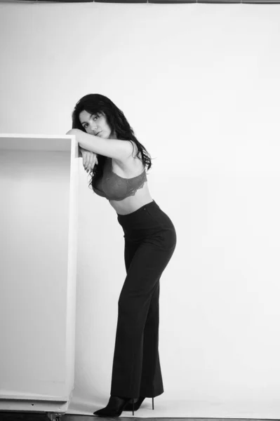 スタジオでポーズをとっている黒い服を着た美しい若い女性 — ストック写真