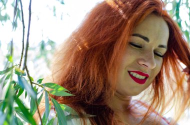 Kızıl saçlı güzel bir genç kadının portresi.  