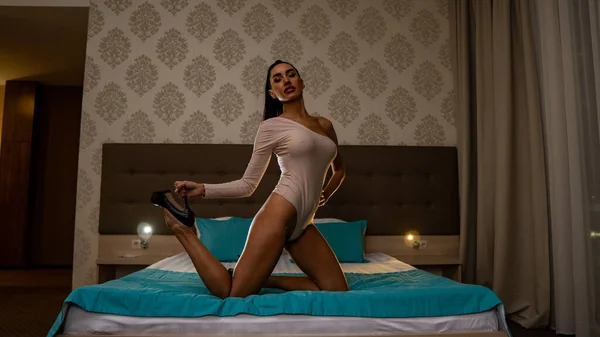 美しいセクシーな若い女性が部屋のベッドの上でポーズ — ストック写真