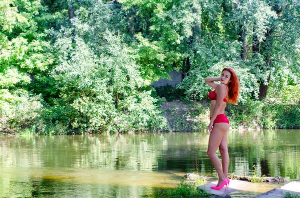 身穿红色内衣的年轻漂亮的女人站在湖边 — 图库照片