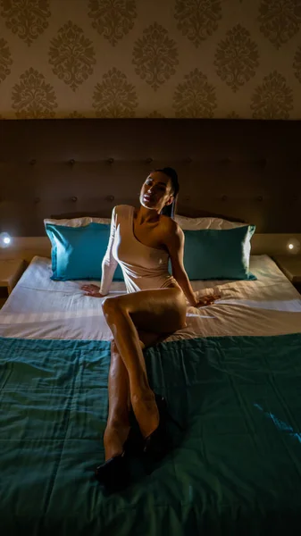 美しいですセクシー若いです女性でボディスーツ姿のベッドの上に横になって部屋に — ストック写真
