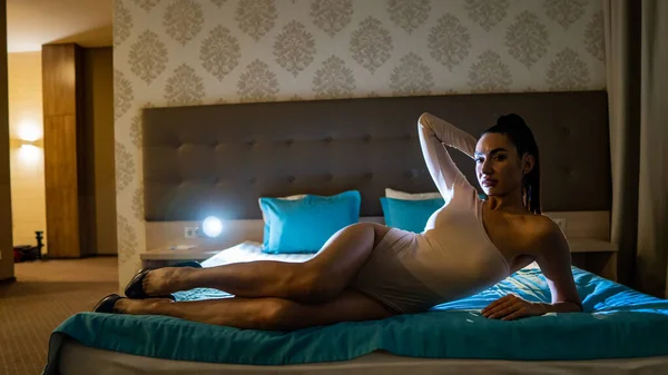 美しいですセクシー若いです女性でボディスーツ姿のベッドの上に横になって部屋に — ストック写真