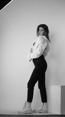 Stüdyoda uzun saçlı, uzun saçlı, siyah beyaz bir kadın poz veriyor..  