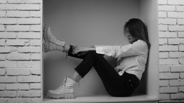 Stüdyoda uzun saçlı, uzun saçlı, siyah beyaz bir kadın poz veriyor..  