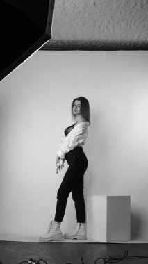 Stüdyoda uzun saçlı, uzun saçlı, siyah beyaz bir kadın poz veriyor..  