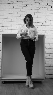 Stüdyoda uzun saçlı, uzun saçlı, siyah beyaz bir kadın poz veriyor..  