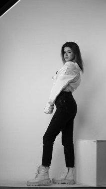 Stüdyoda uzun saçlı, uzun saçlı, siyah beyaz bir kadın poz veriyor..  