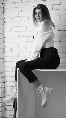 Stüdyoda uzun saçlı, uzun saçlı, siyah beyaz bir kadın poz veriyor..  