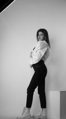 Stüdyoda uzun saçlı, uzun saçlı, siyah beyaz bir kadın poz veriyor..  