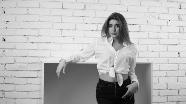 Stüdyoda uzun saçlı, uzun saçlı, siyah beyaz bir kadın poz veriyor..  