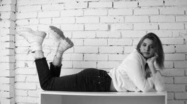 Stüdyoda uzun saçlı, uzun saçlı, siyah beyaz bir kadın poz veriyor..  