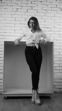 Stüdyoda uzun saçlı, uzun saçlı, siyah beyaz bir kadın poz veriyor..  