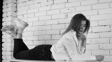 Stüdyoda uzun saçlı, uzun saçlı, siyah beyaz bir kadın poz veriyor..  