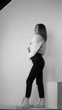 Stüdyoda uzun saçlı, uzun saçlı, siyah beyaz bir kadın poz veriyor..  