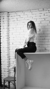 Stüdyoda uzun saçlı, uzun saçlı, siyah beyaz bir kadın poz veriyor..  