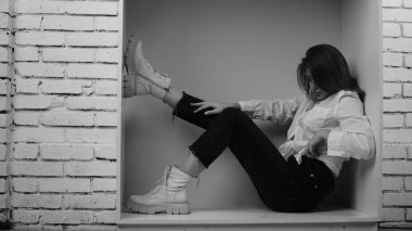 Stüdyoda uzun saçlı, uzun saçlı, siyah beyaz bir kadın poz veriyor..  