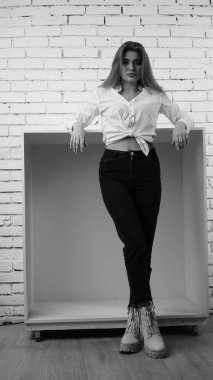 Stüdyoda uzun saçlı, uzun saçlı, siyah beyaz bir kadın poz veriyor..  