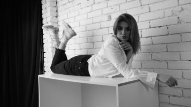 Stüdyoda uzun saçlı, uzun saçlı, siyah beyaz bir kadın poz veriyor..  