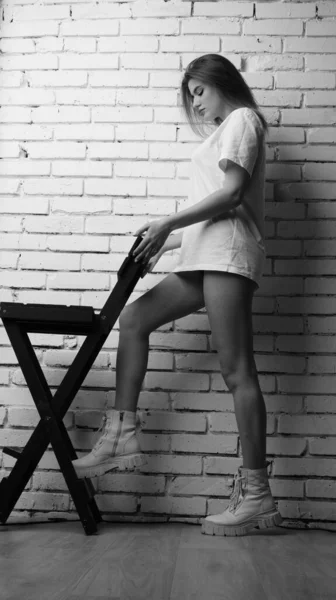 Stüdyoda Sandalyenin Yanında Uzun Saçlı Siyah Beyaz Bir Kadın Poz — Stok fotoğraf